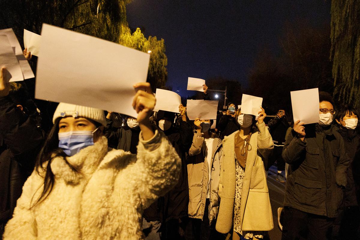 People hold white sheets of paper in protest of COVID-19 restrictions, after a vigil for the victims of a fire in Urumqi, as outbreaks of the coronavirus disease continue in Beijing, China, November 27, 2022. 