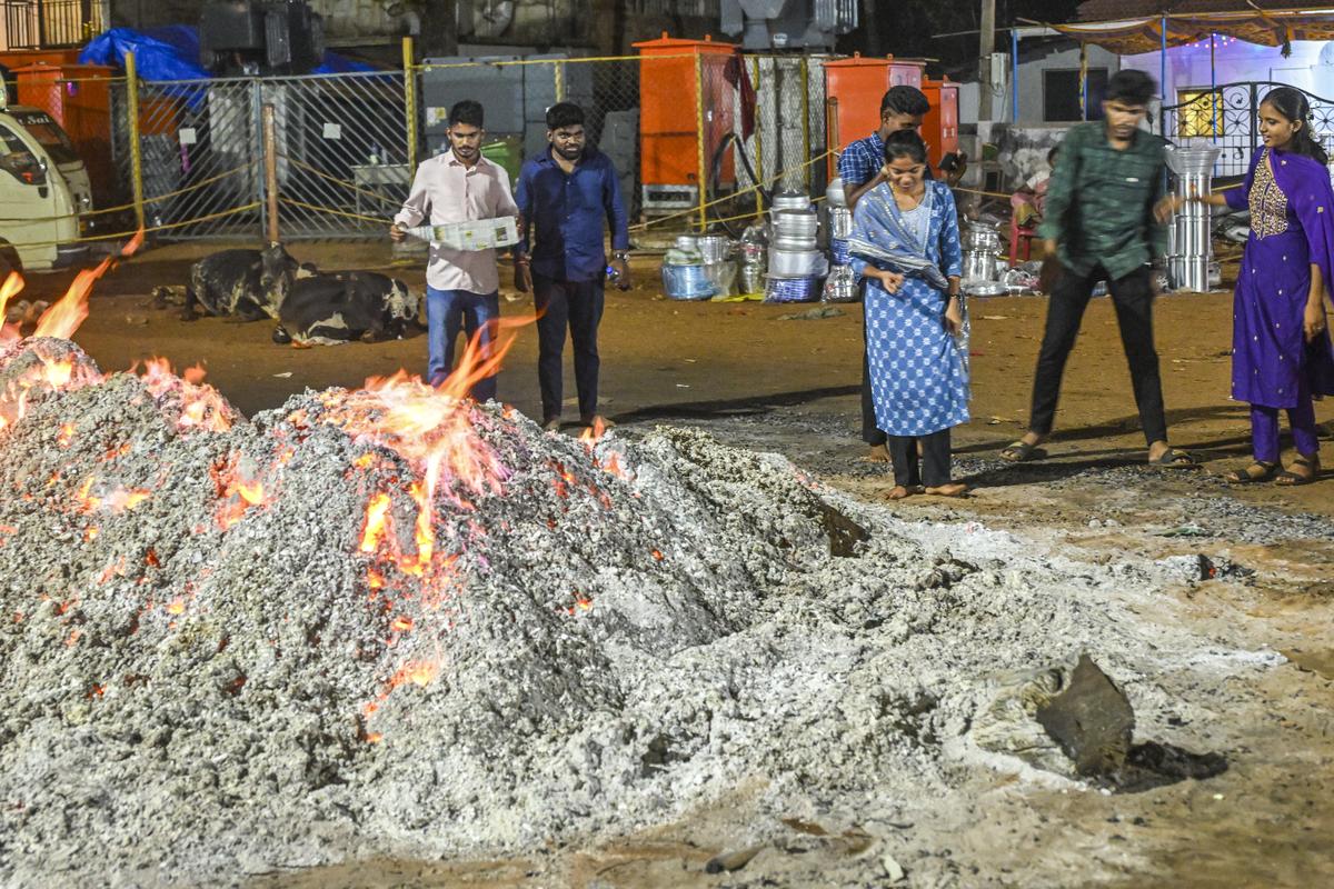 People collecting ashes from the embers on which the dhonds walk outside the Lairai Devi temple in Shirgao, Goa. 