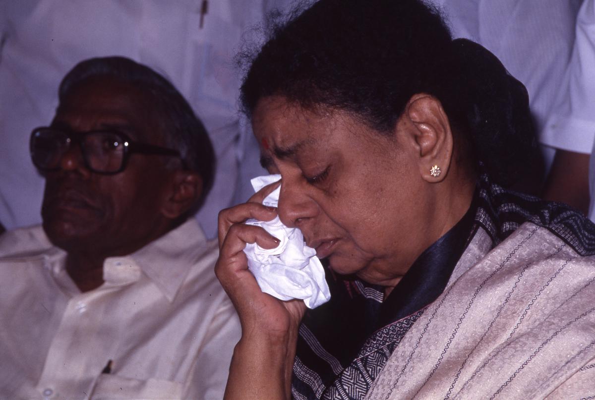 Janaki Ramachandran, wife of the late M.G. Ramachandran, in a sombre mood, at Ramavaram Gardens in Madras on December 31, 1987.  AIADMK leader R.M. Veerappan is also seen.  