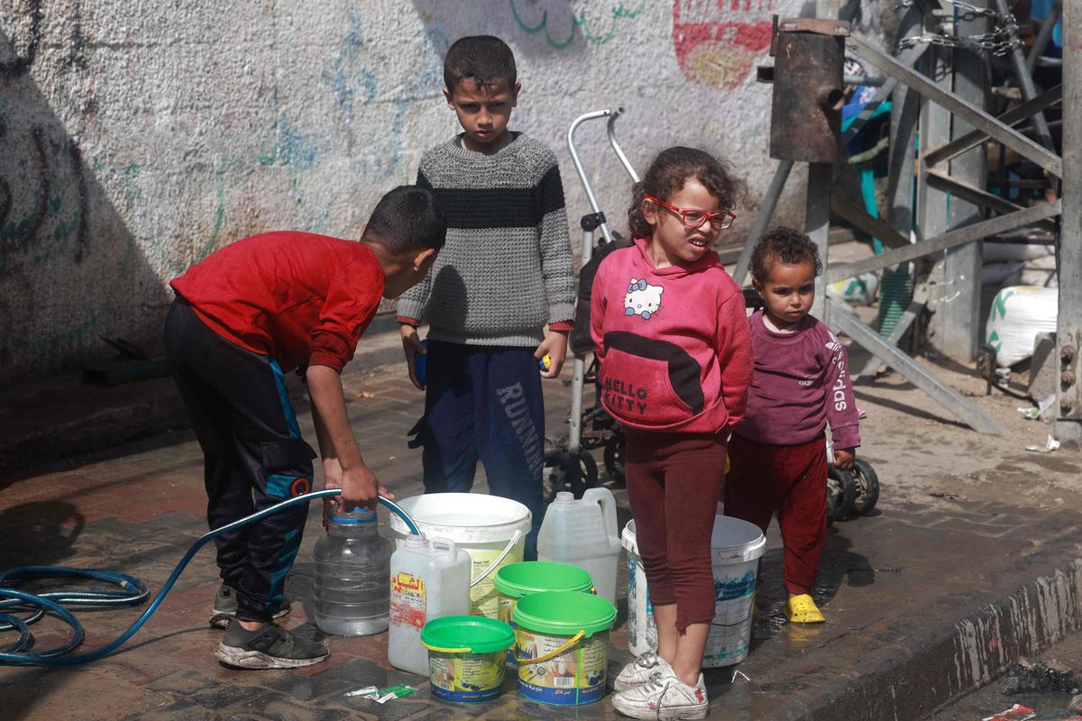 Palestinian children fetch water in Rafah in the southern Gaza Strip on March 30, 2024, amid the ongoing conflict between Israel and Hamas. 
