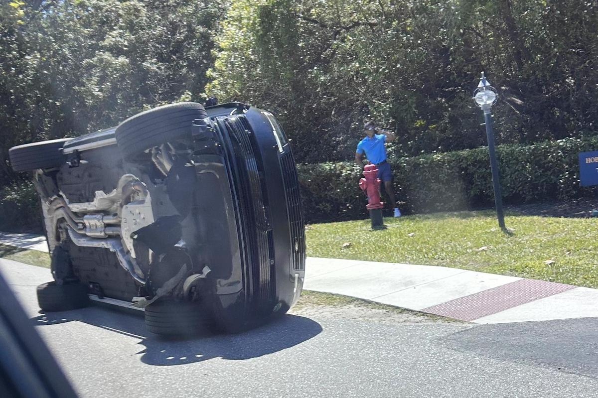 Golfer Tiger Woods stands by his overturned vehicle in Jupiter Island. File