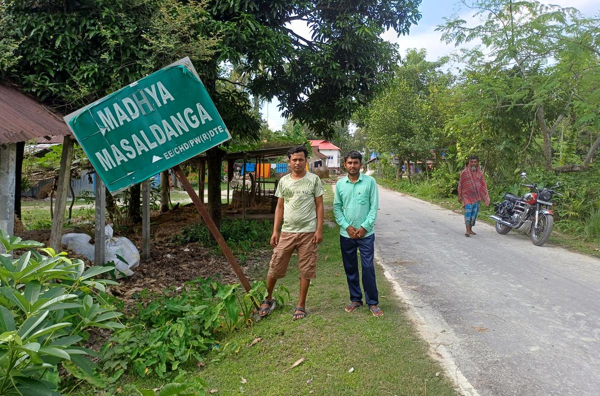 Joynal Abedin and Saddam Hossain stand next to a board identifying Madhya Masaldanga, an erstwhile Bangladeshi enclave that became part of Indian territory after the Land Boundary Agreement 2015. Joynal and Saddam are prominent faces who campaigned for swap of the enclaves. 