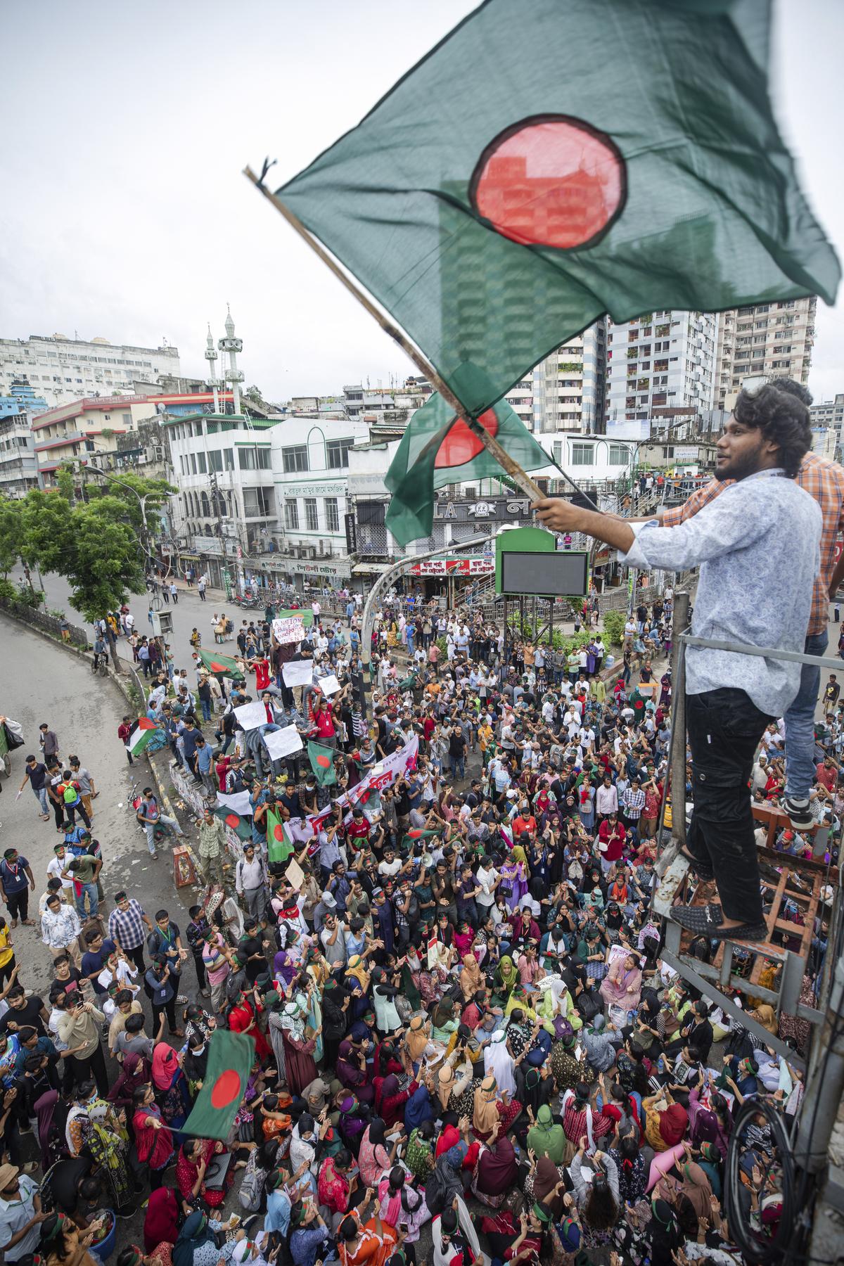 An activist waves the Bangladesh flag during a protest march against Prime Minister Sheikh Hasina and her government to demand justice for the victims killed in the recent countrywide deadly clashes, in Dhaka, Bangladesh.