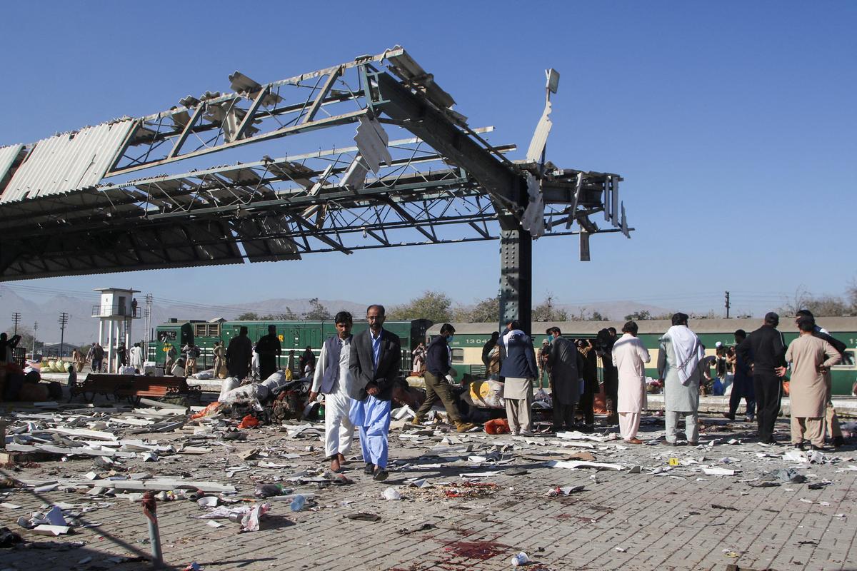 People walk amid the debris after a bomb blast at a railway station in Quetta, Pakistan, on November 9, 2024.