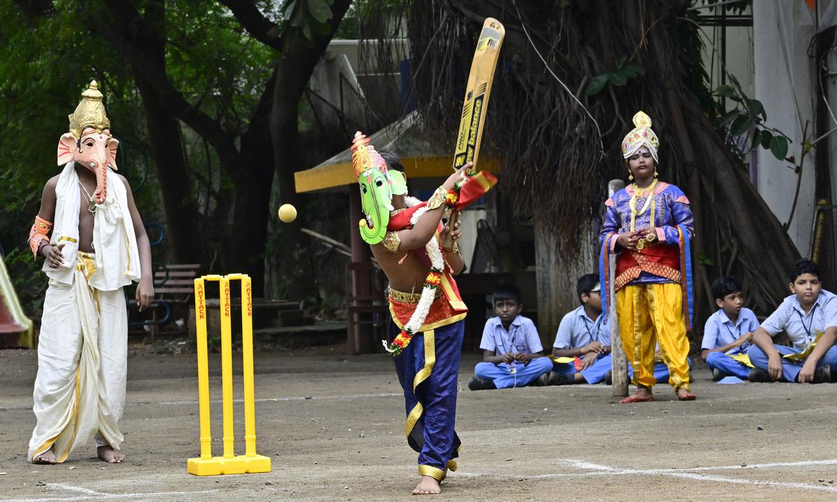 Youngsters adroed with Lord Ganesha mask playing cricket at a school in Chennai. 