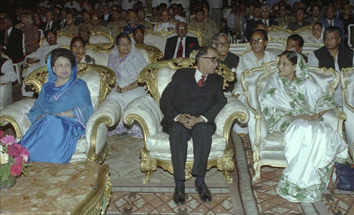 Former Bangladeshi Prime Minister Khaleda Zia, left, looks over as new interim leader Mohammad Habibur Rahman speaks with opposition Awami League leader Sheikh Hasina, right, at Rahman’s swearing-in ceremony in Dhaka on Saturday, March 30, 1996