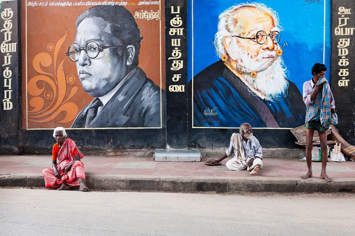 Dalits sitting by wall paintings of Ambedkar and Periyar, both famous for their fight against discrimination.