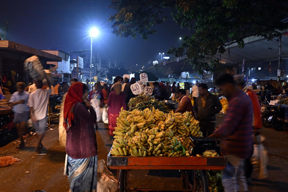 Footpath vendors gathered early morning to distribute and sell vegetables fruits and flowers near Krishna Rajendra Market.