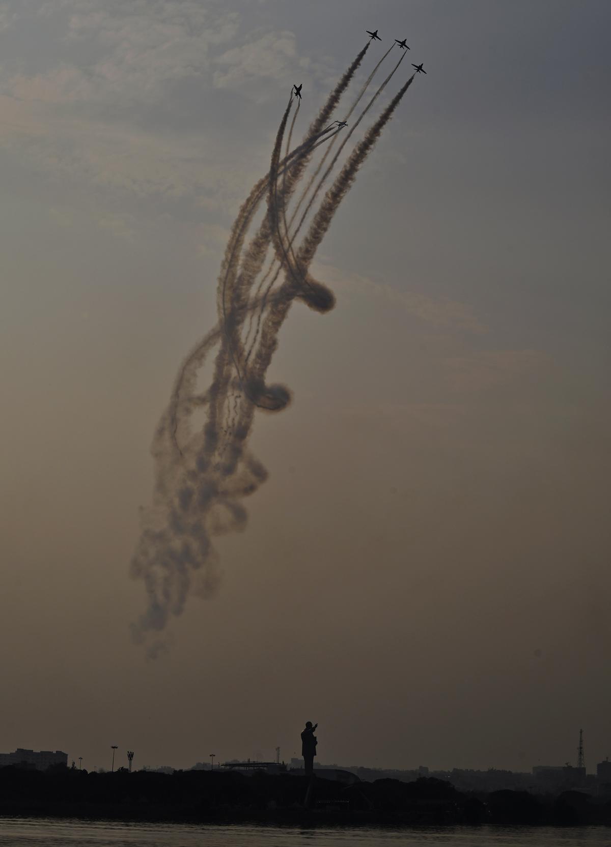 Indian Air Force’s Surya Kiran Aerobatic Team flights are seen against at the Dr. B.R. Ambedkar State Secretariat building complex in Hyderabad on Friday (December 6, 2024)