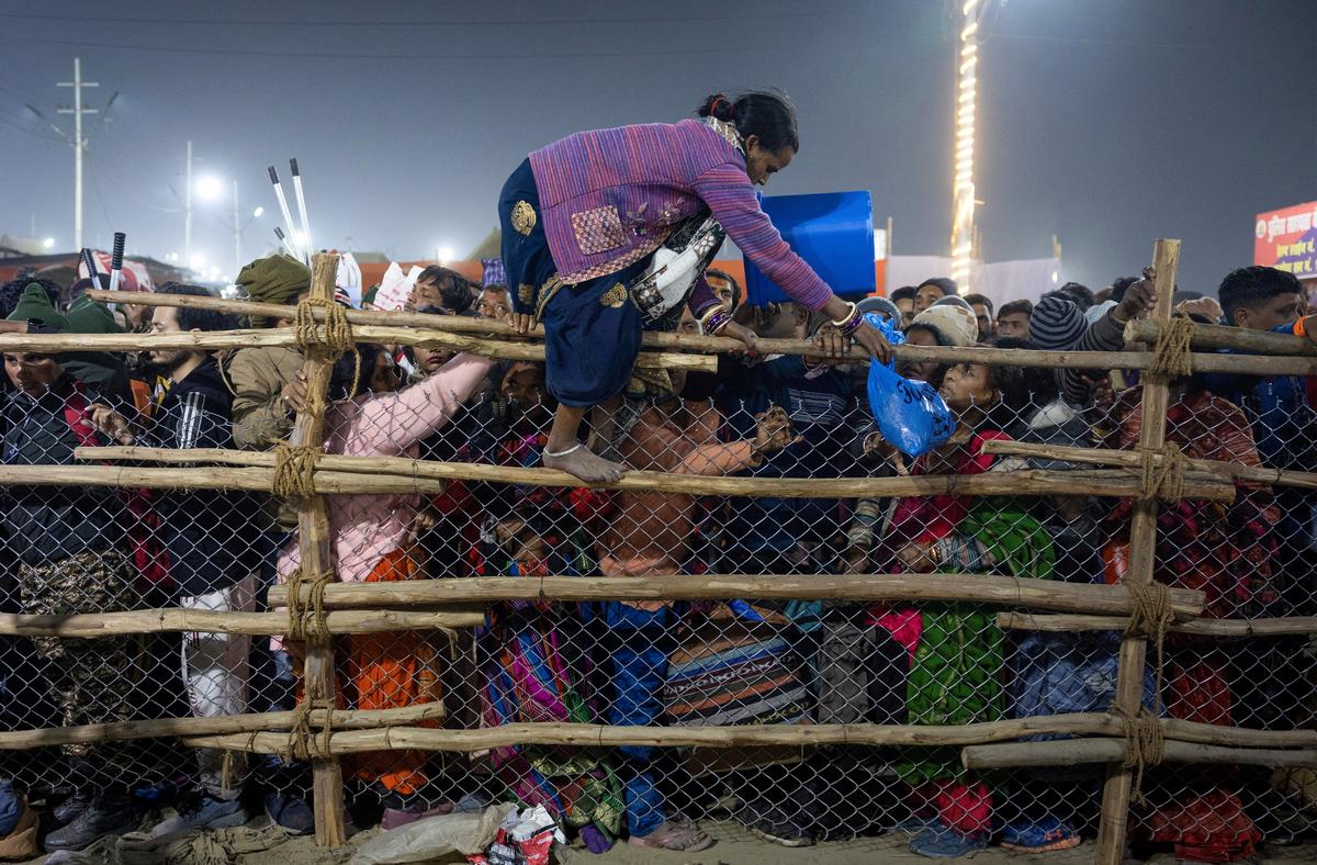A devotee crosses over a barricade after the stampede.