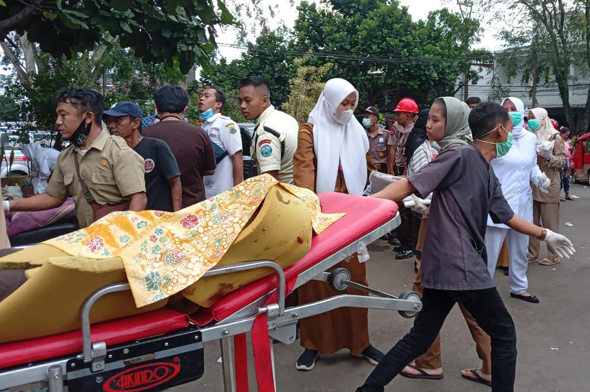 A hospital worker carries an earthquake victim on a gurney outside a hospital in Cianjur, West Java, Indonesia on November 21, 2022. 