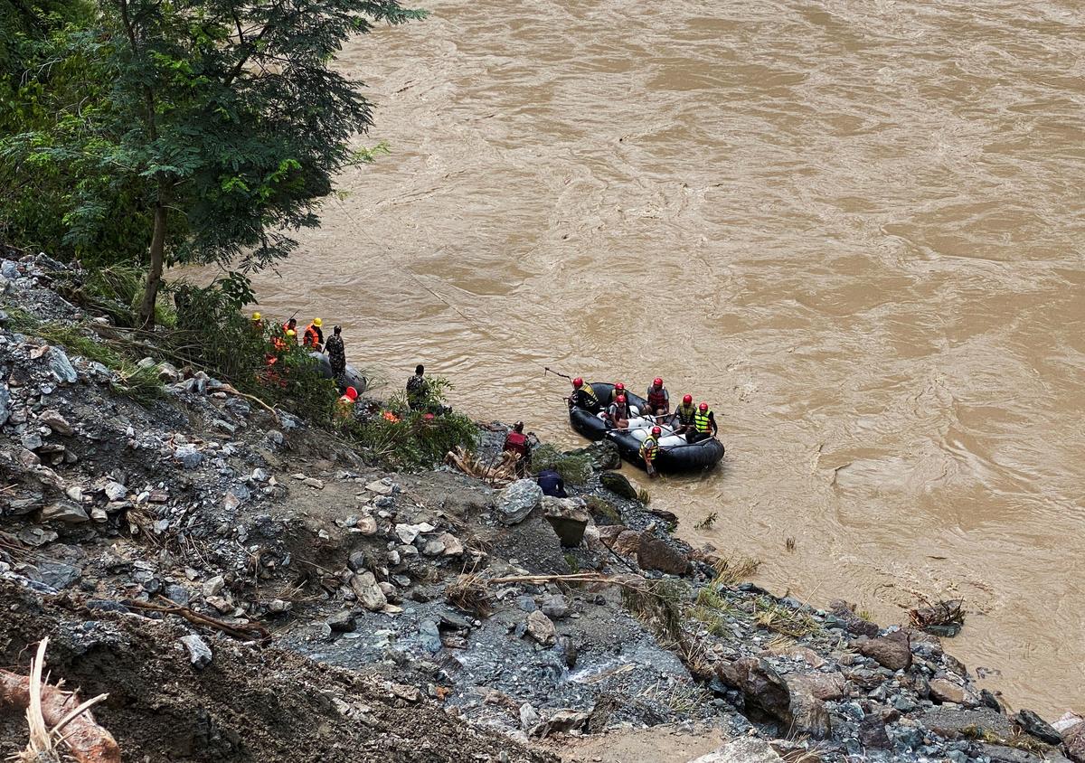 Members of rescue team search for the passenger buses that fell into the Trishuli River after the landslide at Simaltal area in Chitwan district, Nepal.