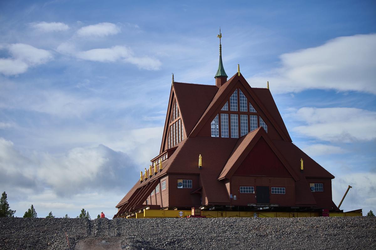 A construction worker sits next to the Kiruna Church, a Sami style wooden Swedish Lutheran church, called Kiruna Kyrka in Swedish, in Kiruna, Sweden, Wednesday, Aug. 20, 2025, after the completion of its move along a 5-km. (3-mile) route east to a new city centre as part of the town’s relocation.