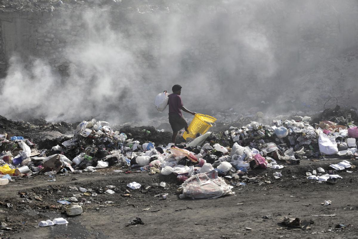A woman walks through a landfill looking for salvageable items, in Port-au-Prince, Haiti, July 1, 2023. 