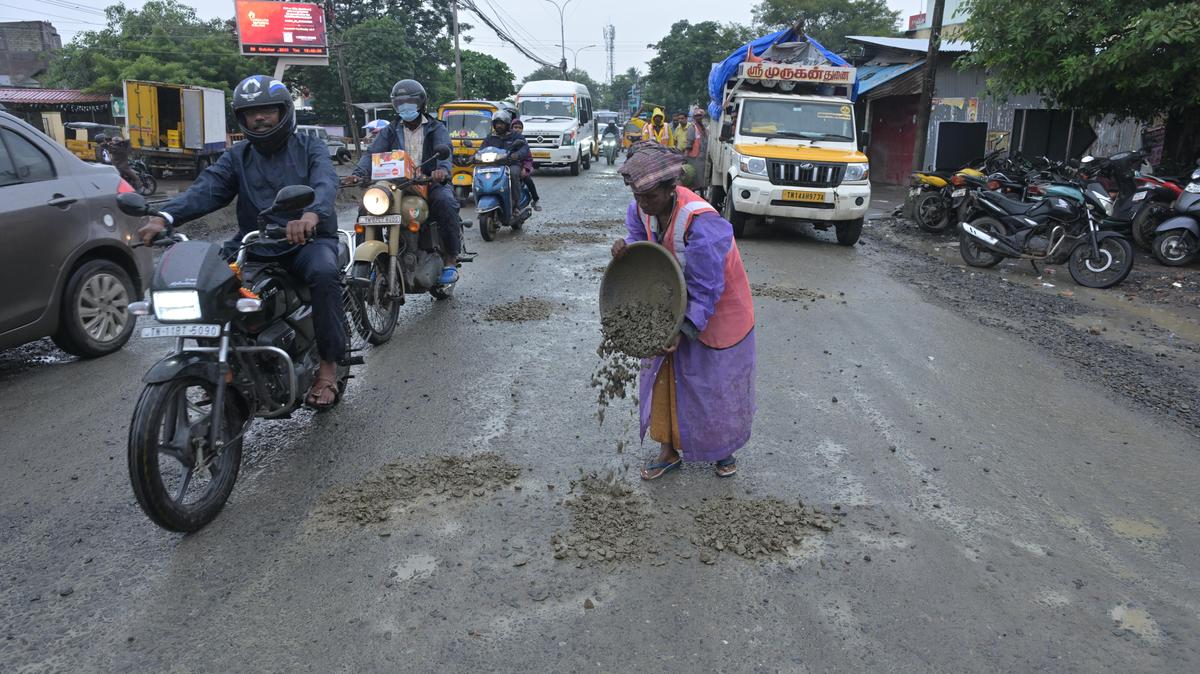 a worker patching up the recently laid Tambaram-Velachery Road in Pallikaranai on Tuesday, after it was damaged due to rain.