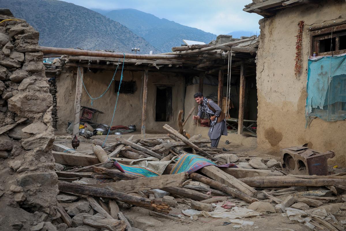 An Afghan man looks for his belongings amidst the rubble of a collapsed house after a deadly magnitude-6 earthquake that struck Afghanistan around midnight, in Dara Noor, in Jalalabad on September 1, 2025.