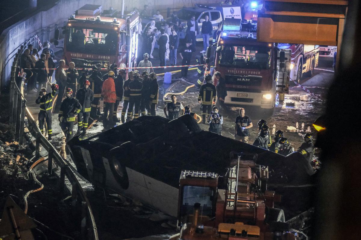 Emergency crew members work at the scene after a bus accident near Venice on October 3, 2023 in Mestre, Italy. A bus belonging to the transport company La Linea plunged from an overpass between Mestre and Marghera, plunging 10 meters and catching fire shortly before 8 p.m