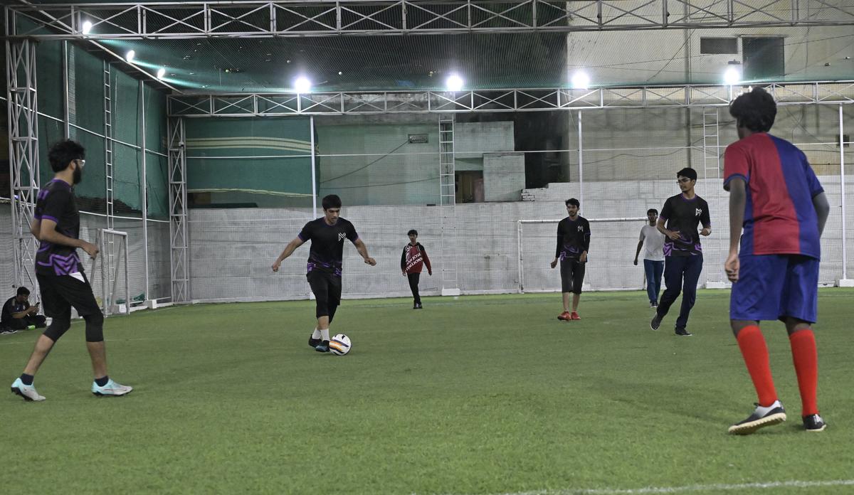 People play a late-night football match under floodlights at Game On turf in Hyderabad. File