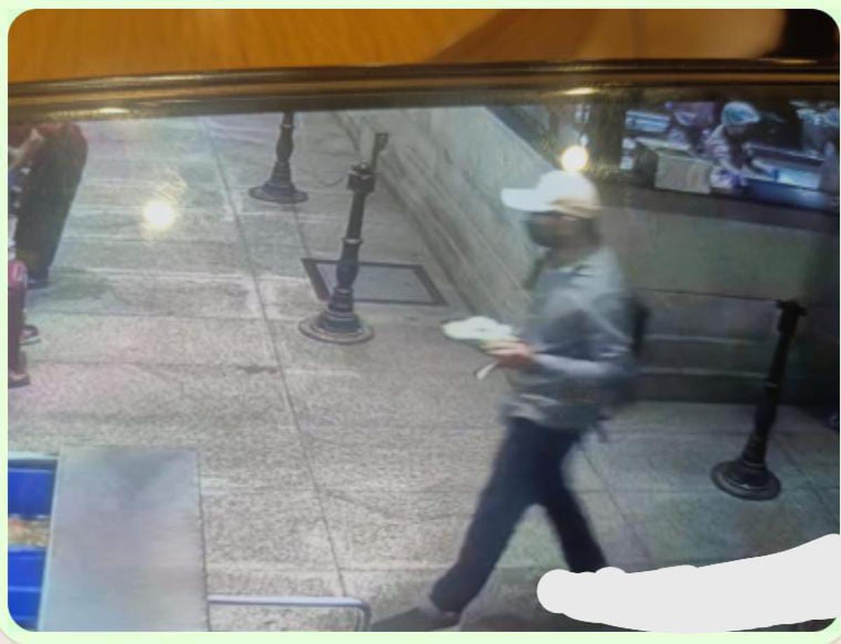CCTV camera footage shows the suspect wearing a white cap and a black face mask. He appears to be carrying a bag on his shoulder.