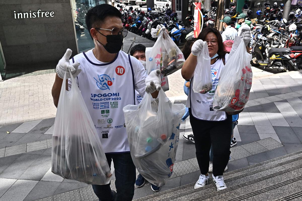 Contestants for the Thailand Stage of the Spogomi World Cup 2023 show off bags of litter during the trash picking competition in Bangkok on July 2, 2023. 