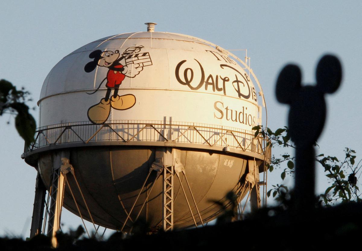 The water tower at The Walt Disney Co., featuring the character Mickey Mouse, is seen behind a silhouette of mouse ears on the fencing surrounding the company’s headquarters in Burbank, California, February 7, 2011
