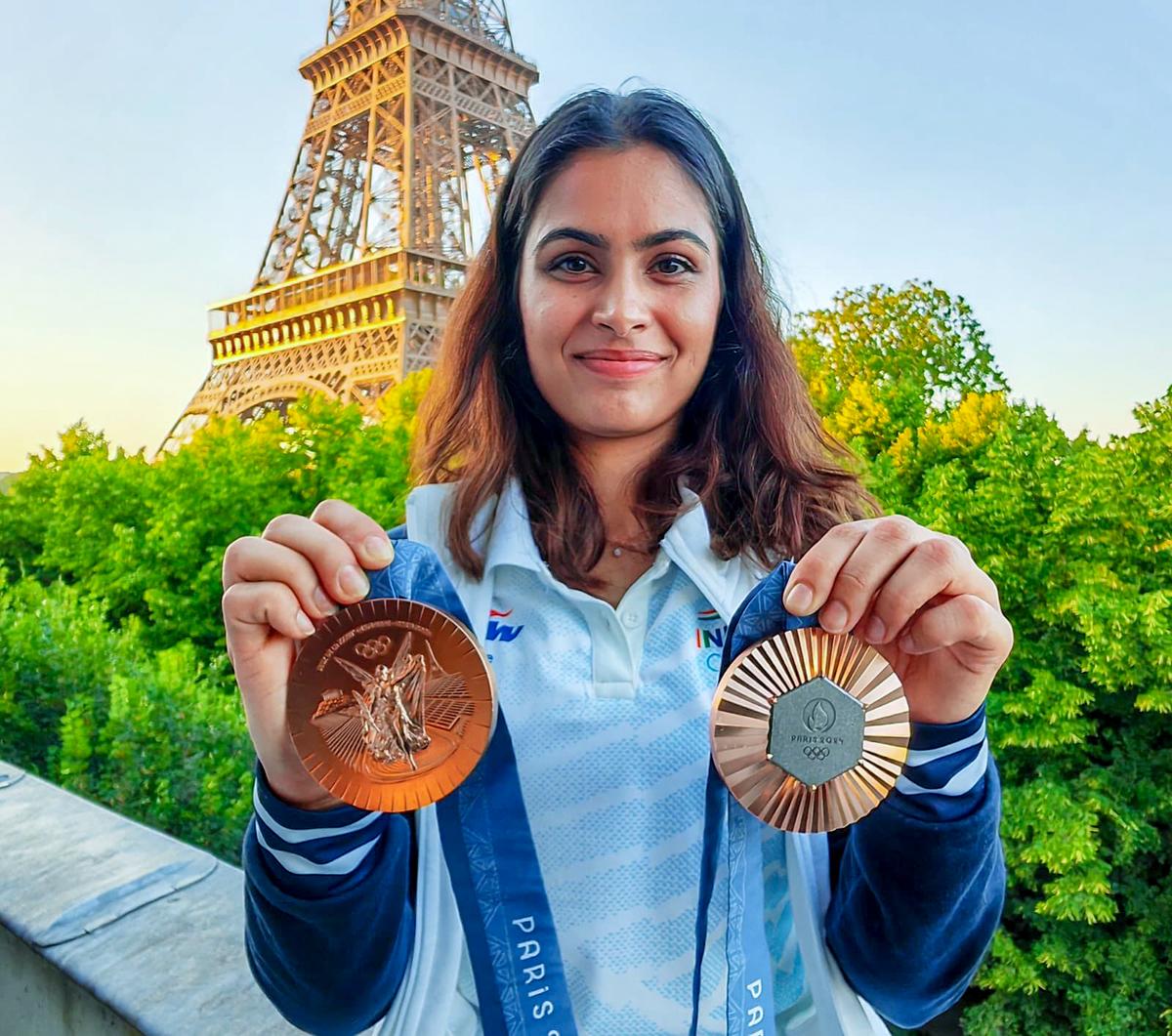 Shooter Manu Bhaker poses for a photo with her bronze medals against the iconic backdrop of the Eiffel Tower during the Paris 2024 Olympic Games, in Paris on August 5, 2024.