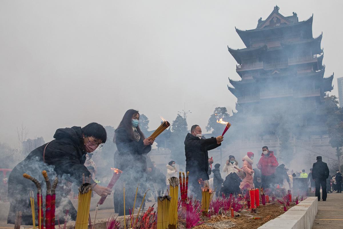 People wear masks as they pray for the Spring Festival at the Guiyuan temple on January 22, 2023 in Wuhan, Hubei Province, China.