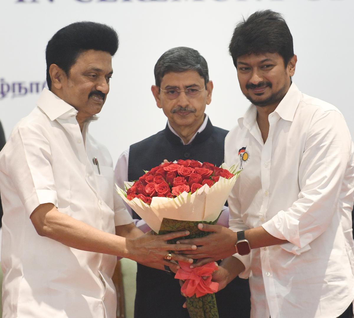 M. K. Stalin, Tamil Nadu Chief Minister, giving away a flower bouquet to the newly sworn in Minister Udayanidhi Stalin, Minister for Youth Welfare & Sports Development in Chennai on December 14, 2022. The Tamil Nadu Governor R.N. Ravi looks on. 