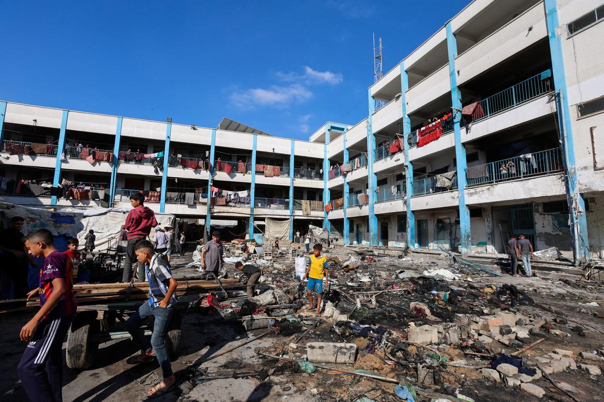 Palestinians inspect the site of an overnight Israeli strike on a school sheltering displaced people, in Bureij refugee camp, in the central Gaza Strip, July 8, 2025. 