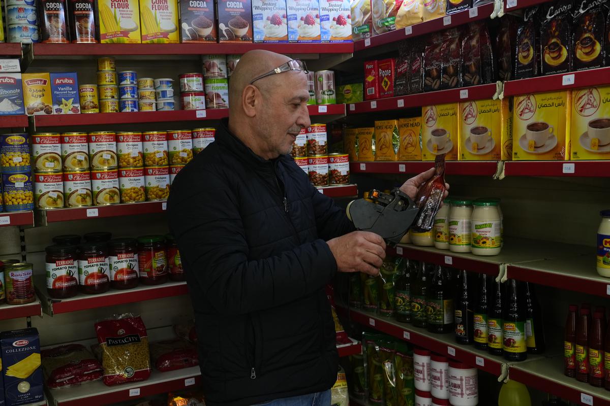 Moheidein Bazazo changes price tags from Lebanese pound to the U.S. dollar in a shop in in Beirut, Lebanon, Wednesday, March 1, 2023. Lebanon began pricing consumer goods in supermarkets in U.S. dollars Wednesday as the value of the Lebanese pound hit new lows.