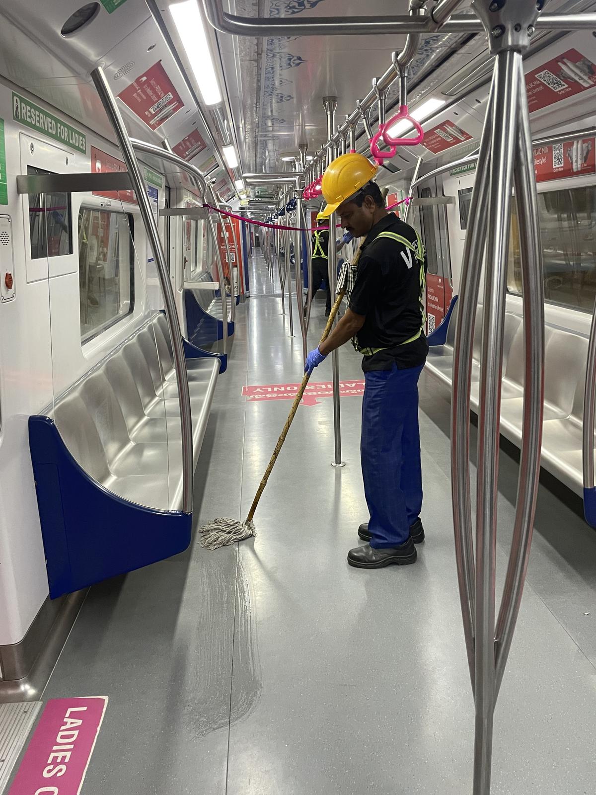 A Hyderabad Metro Rail staffer cleaning a coach. 