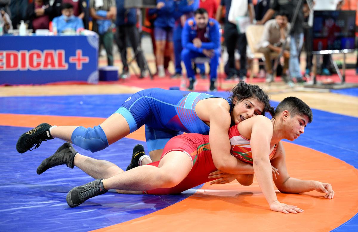 Railways’ Nisha Dahiya , in blue, in action against Delhi's Srishti in the women's 68kg gold medal match at the National Wrestling Championship in Ahmedabad on Friday, December 12, 2025. 
