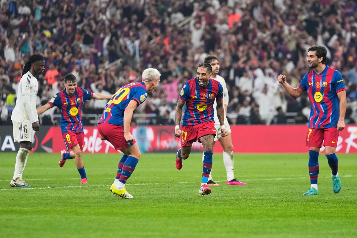Barcelona's Raphinha, center, celebrates after scoring his second goal during the Spanish Super Cup final soccer match against Real Madrid at King Abdullah Sports City Stadium in Jeddah, Saudi Arabia