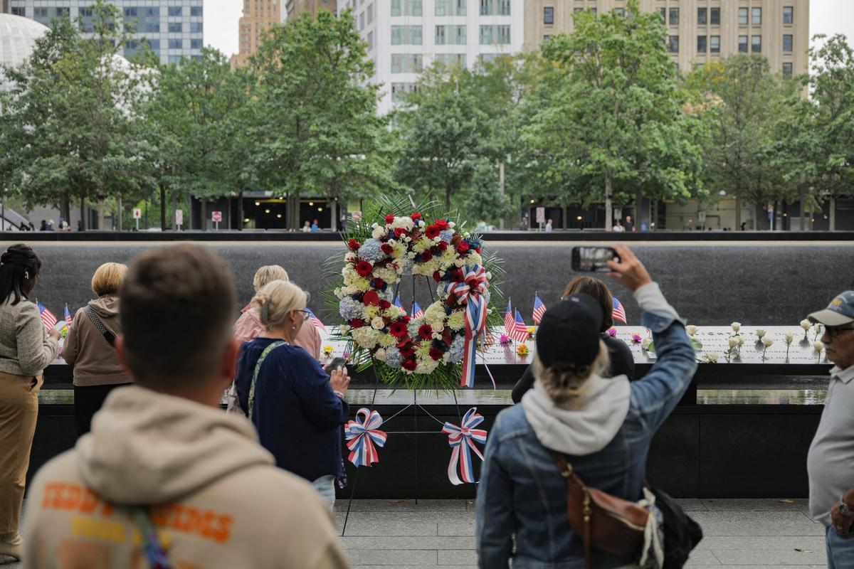 U.S. national flags and flowers are placed at the 9/11 Memorial & Museum reflecting pool ahead of the 24th anniversary of the September 11, 2001 attacks on the World Trade Center, in the Manhattan borough of New York City, on September 10, 2025.