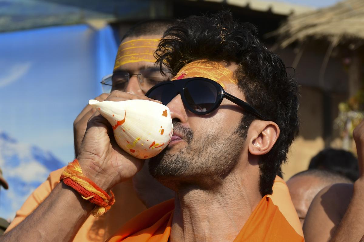 Prayagraj: Bollywood actor Vidyut Jammwal blows a conch shell during his visit on the eve of ‘Magh Purnima’ at the ongoing Maha Kumbh Mela 2025, in Prayagraj, Uttar Pradesh, Tuesday, Feb. 11, 2025.