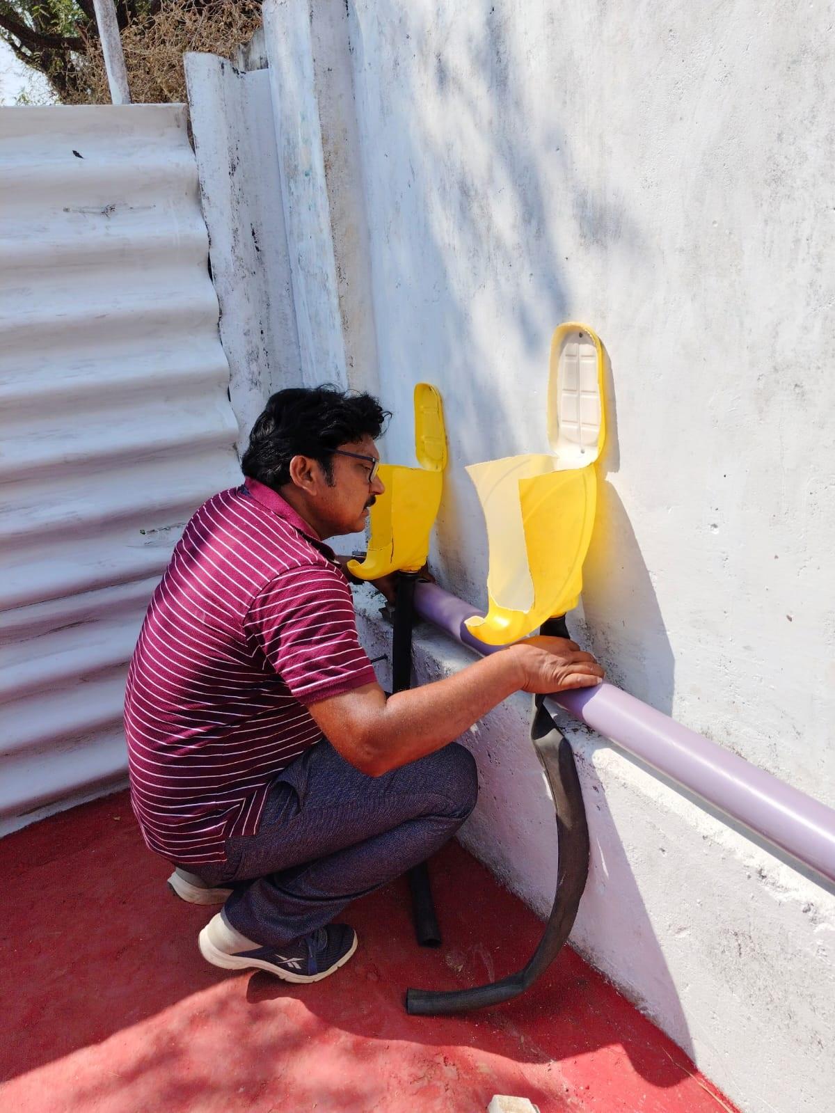 Physical director at ZPHS Rajole, P.Kashinath installing the urinals that he built with the help of students. Physical director at ZPHS Rajole, P.Kashinath installing the urinals that he built with the help of students.