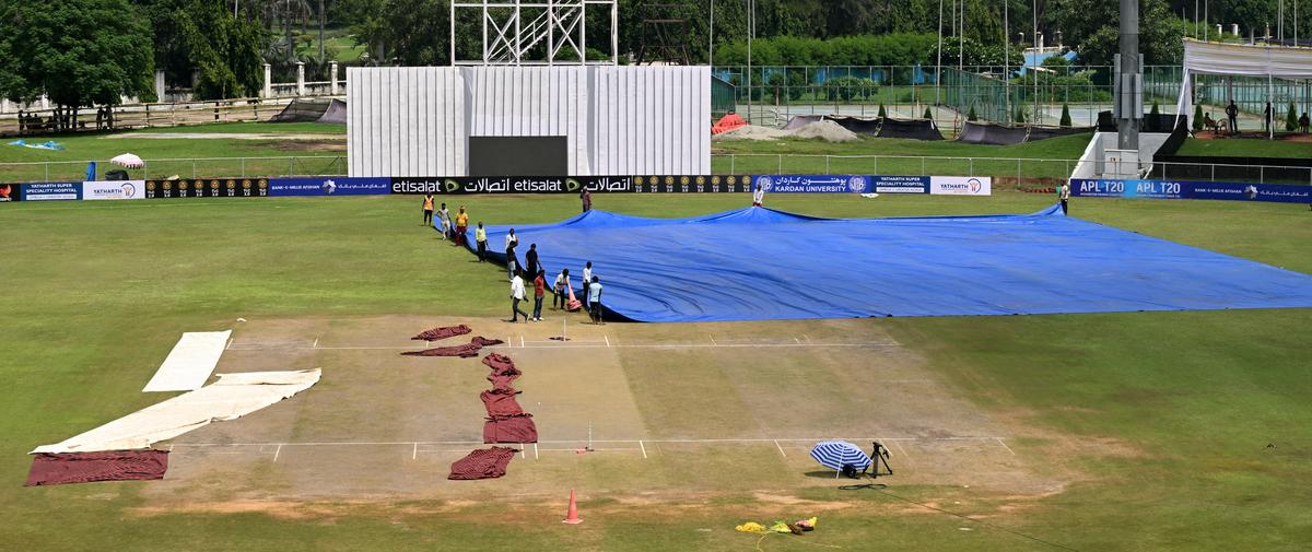 Groundsmen covering the pitch on the second day of the Test Match at Greater Noida in Uttar Pradesh on September 10, 2024. 