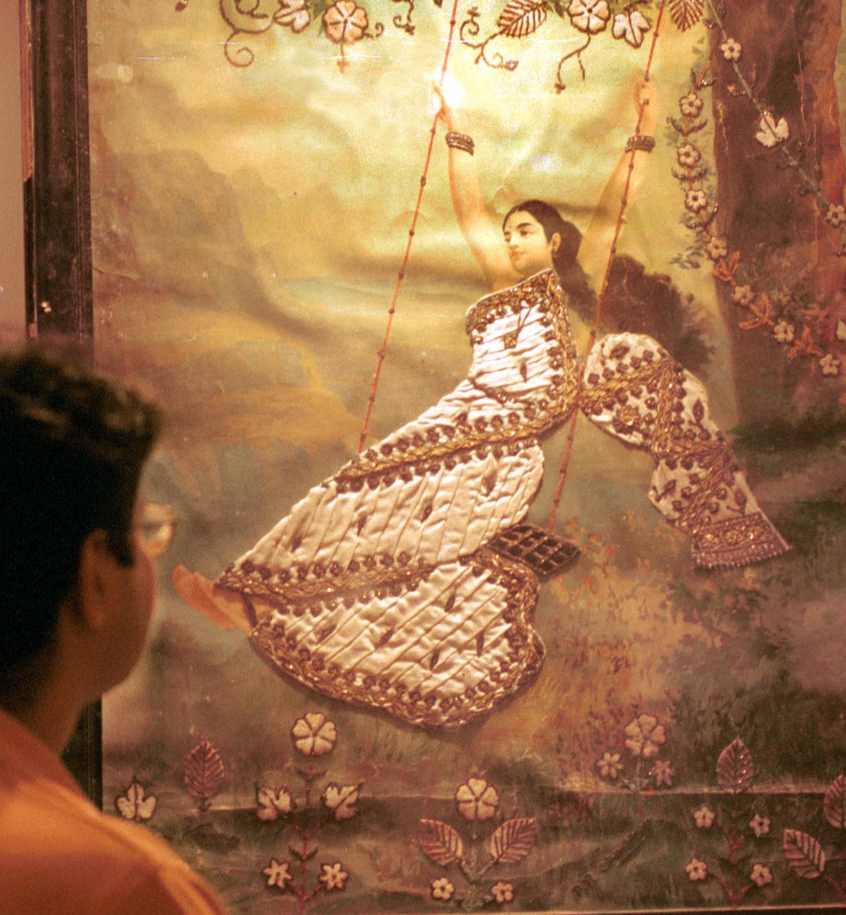     A visitor admires Mohini, a chromolithograph by Ravi Varma. 