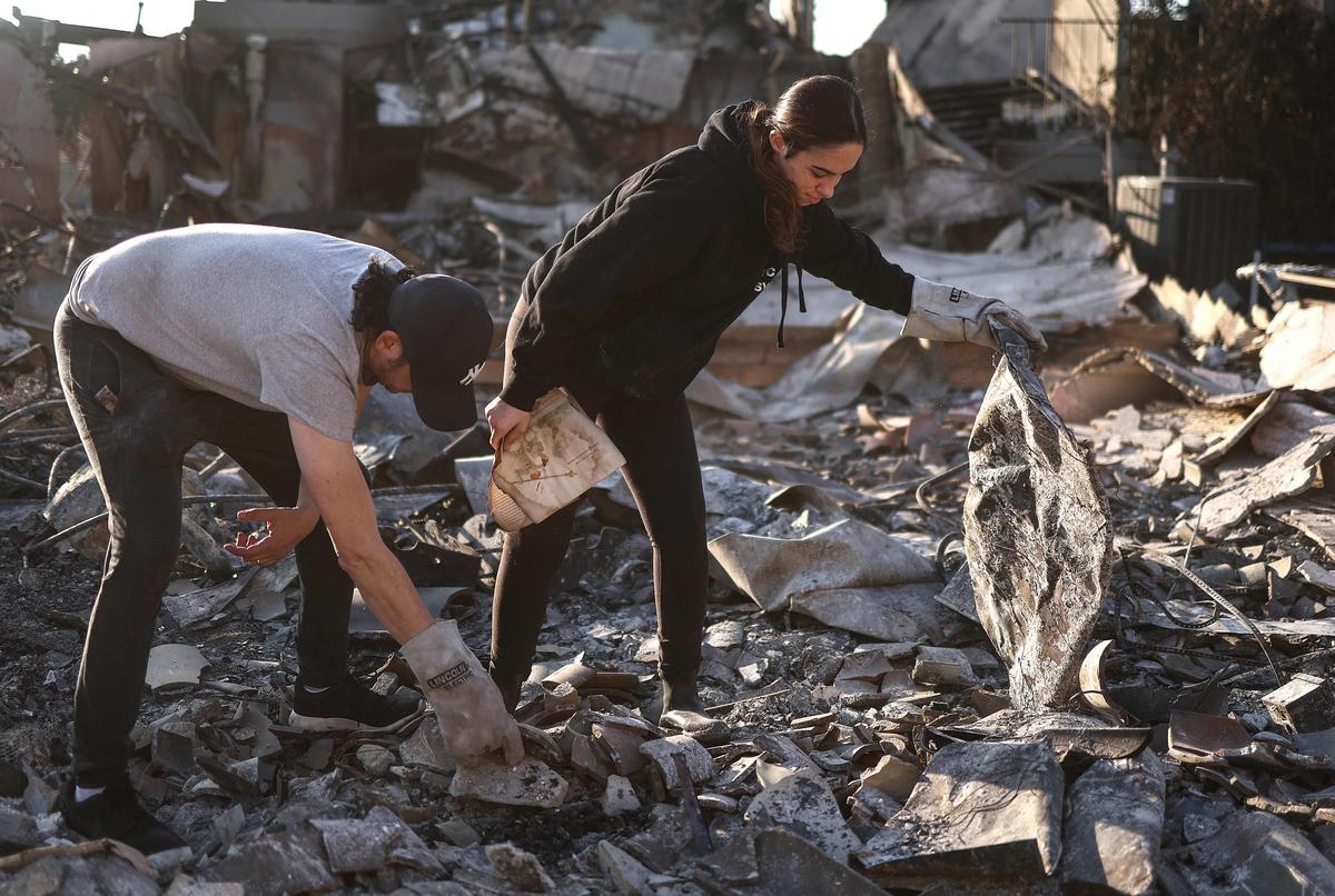 Congregants search through the remains of Pasadena Jewish Temple & Center, which served Pasadena for over 100 years and was destroyed in the Eaton Fire, as wildfires cause damage and loss through the LA region on January 11, 2025 in Pasadena, California.