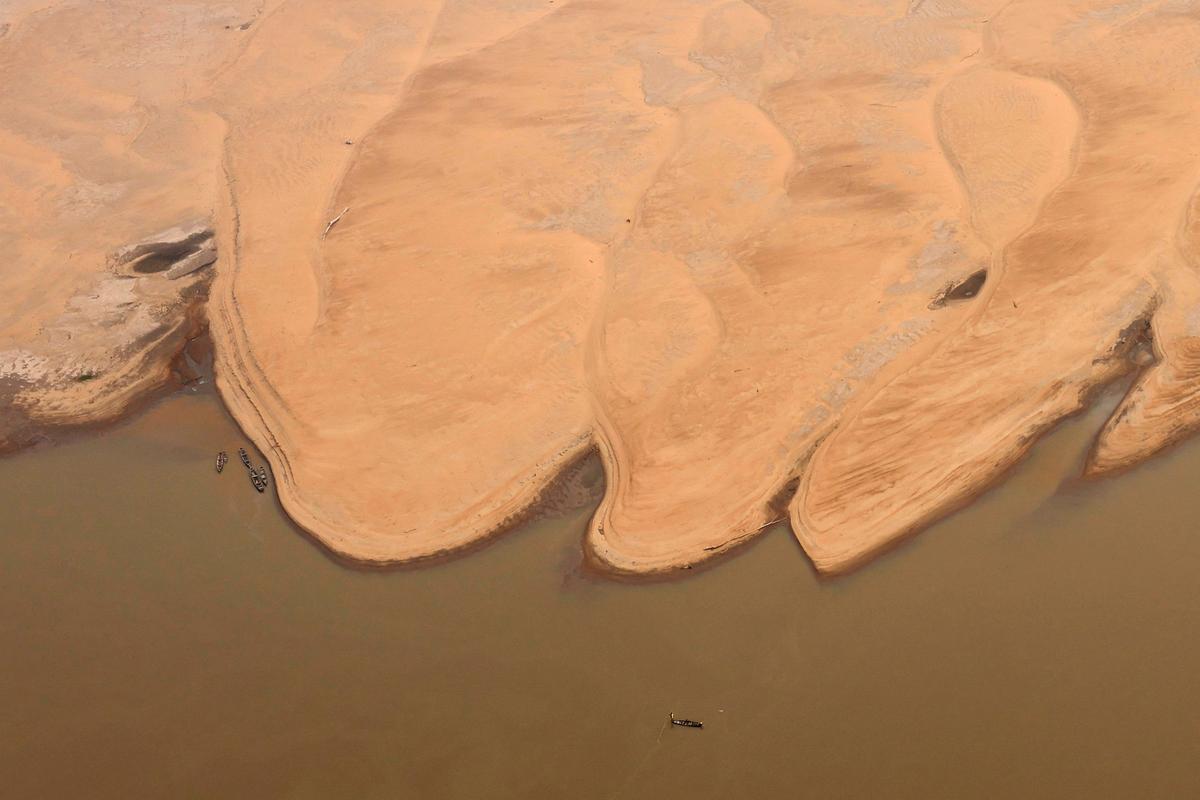 Boats are seen in front of the sandbanks at the Solimoes River, one of the largest tributaries of the Amazon River, during a Greenpeace flyover to inspect what the National Center for Monitoring and Early Warning of Natural Disasters (Cemaden) says is the most intense and widespread drought Brazil has experienced since records began in 1950, near Tefe, Amazonas state, Brazil September 17, 2024. 