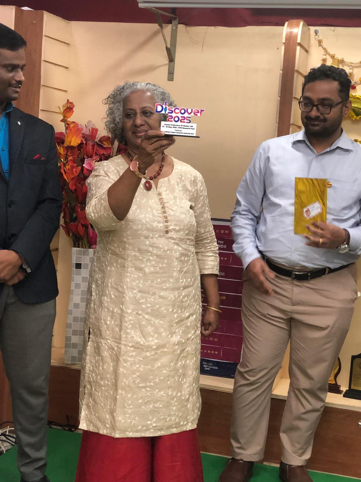 पेशेवर वक्ता, कोच और लेखिका नीना जॉन, डिस्कवर में चेन्नई टोस्टमास्टर्स क्लब को मिले पुरस्कार को प्रदर्शित करती हैं, जो टोस्टमास्टर्स की वार्षिक बैठक है।  