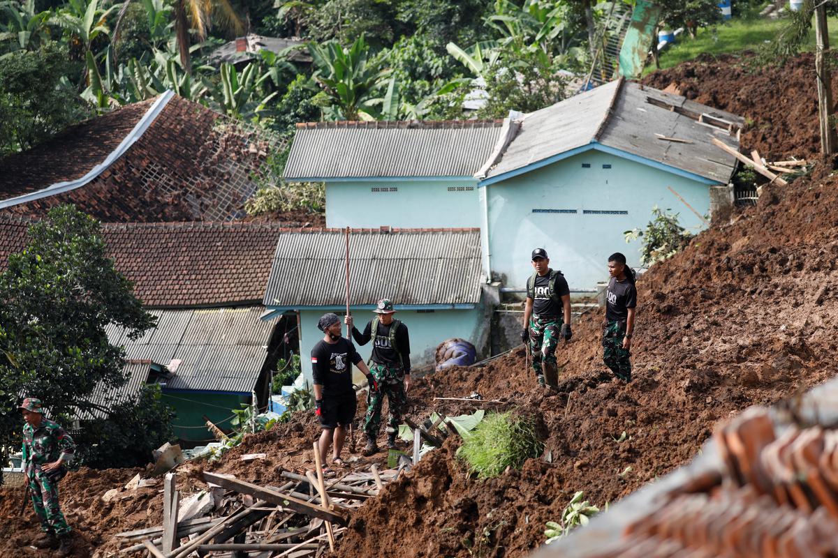 Indonesian Army officers stand as they evacuate people from the site of a landslide caused by the earthquake in Cugenang, Cianjur, West Java province, Indonesia on November 22, 2022.