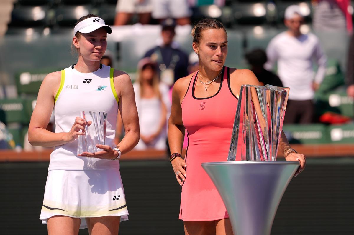 Aryna Sabalenka, of Belarus, celebrates behind the winner's trophy after defeating Elena Rybakina, of Kazakhstan