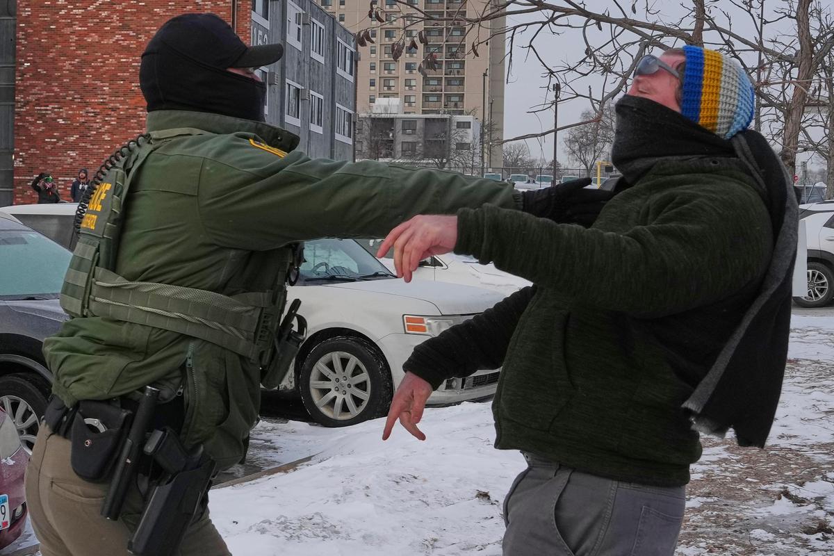 A person is pushed back by a federal agent working on the scene in Minneapolis, on Sunday, Jan. 25, 2026. 