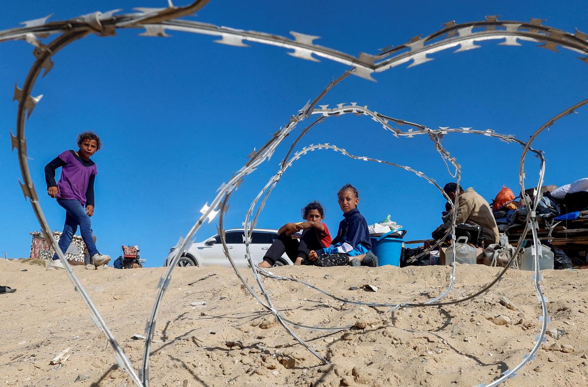 Palestinians sit next to belongings as people flee Rafah after Israeli forces launched a ground and air operation in the eastern part of the southern Gaza city, amid the ongoing conflict between Israel and Hamas, in the southern Gaza Strip on May 9, 2024.