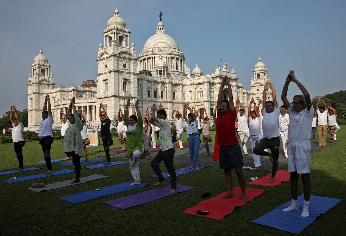 Members of the Central Industrial Security Force (CISF) and their family members perform yoga in front of the historic Victoria Memorial monument, built during British colonial rule, on International Yoga Day in Kolkata, India, on June 21, 2022.