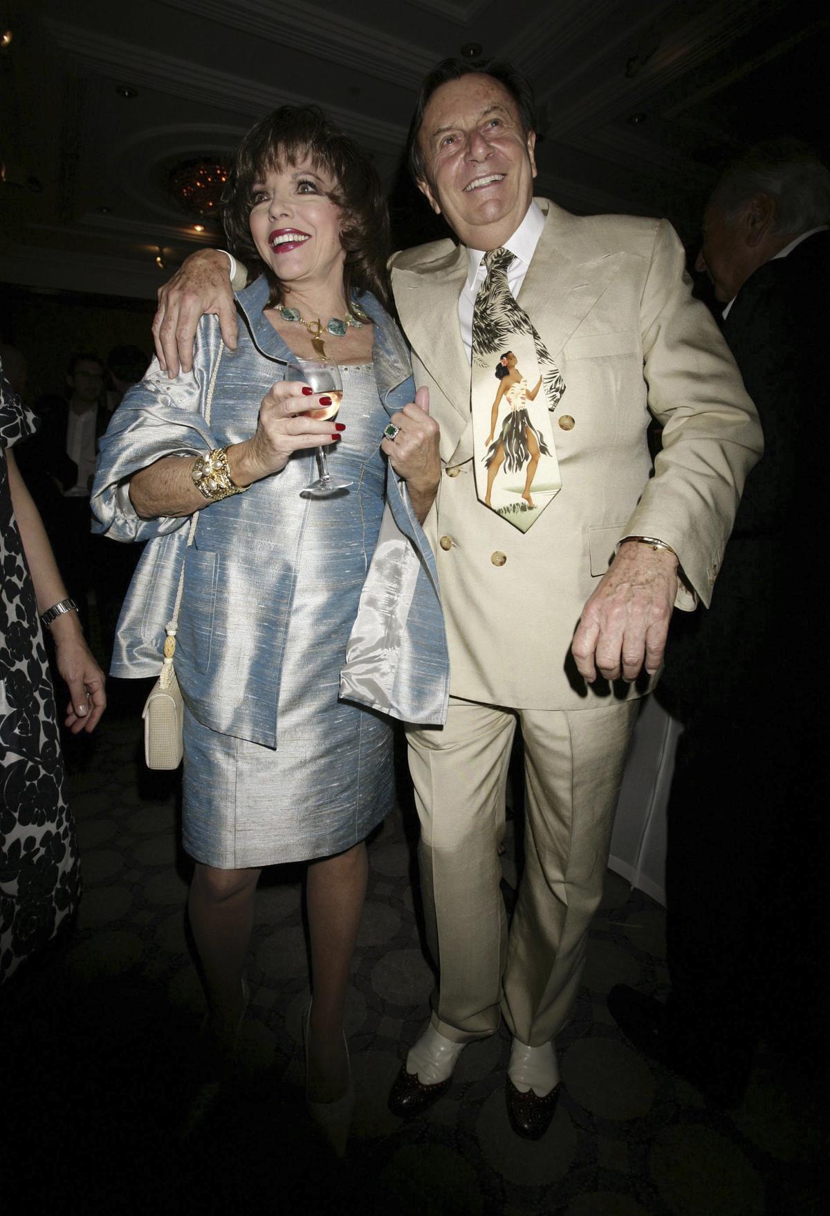 Actress Joan Collins and actor Barry Humphries pose during a party to celebrate the 180th Anniversary of weekly politics magazine The Spectator, held at the Churchill Hyatt Hotel in central London, May 7, 2008. 