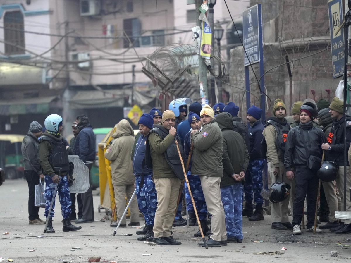 Police and security personnel stand guard near the Syed Faiz Elahi mosque after the demolition of alleged encroachments on a land adjoining the mosque