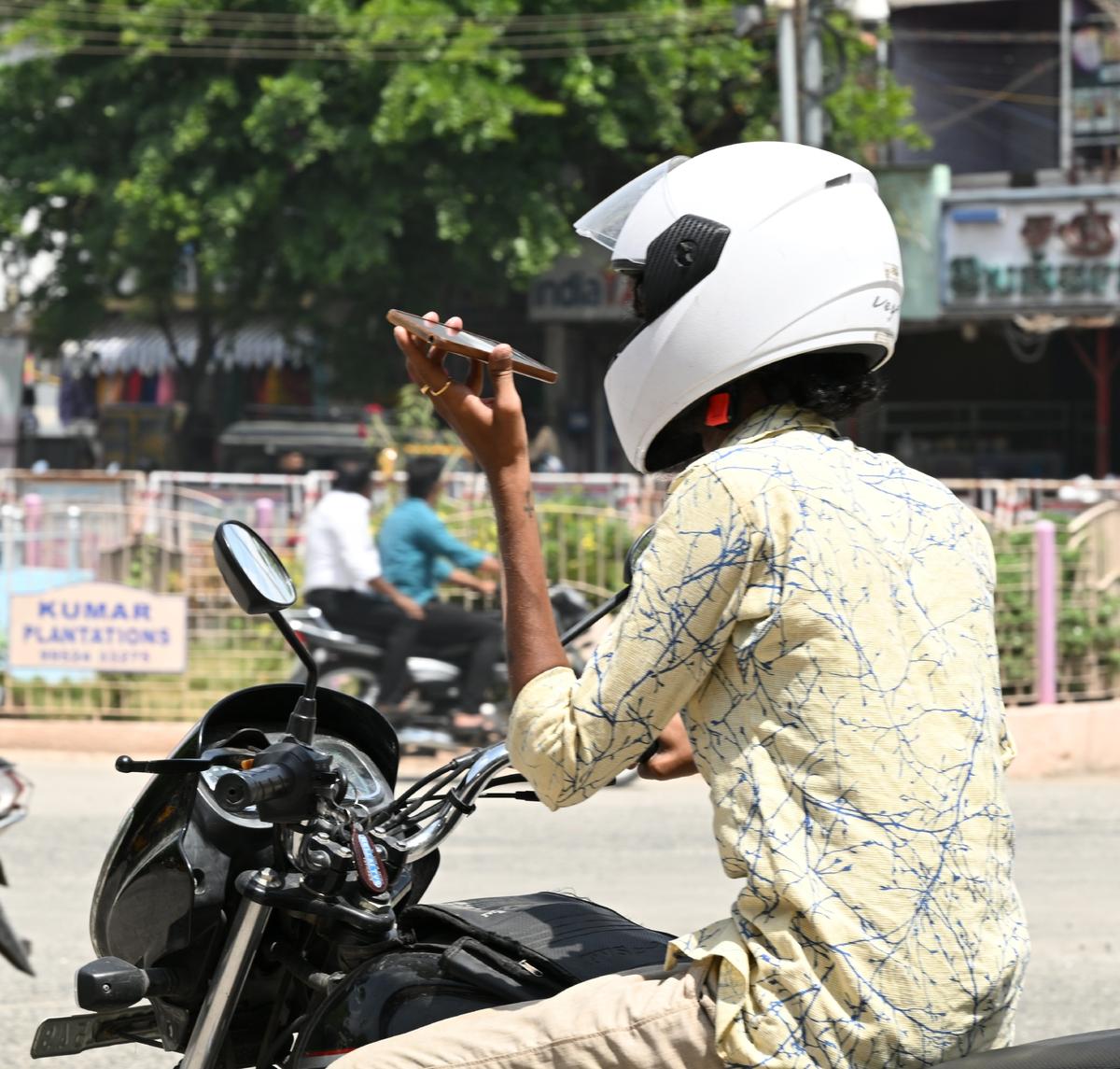 ট্র্যাফিক বিধি লঙ্ঘন: একজন মোটর চালক তার অন্যের সুরক্ষা এবং সুরক্ষার জন্য একটি মোবাইল ফোন ব্যবহার করে।