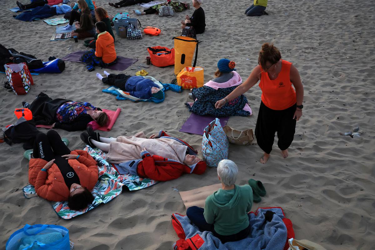 Members of Wild Sea Women take part in a Wild Kundalini Yoga class during sunrise in Seaburn, Britain, on June 21, 2022. 